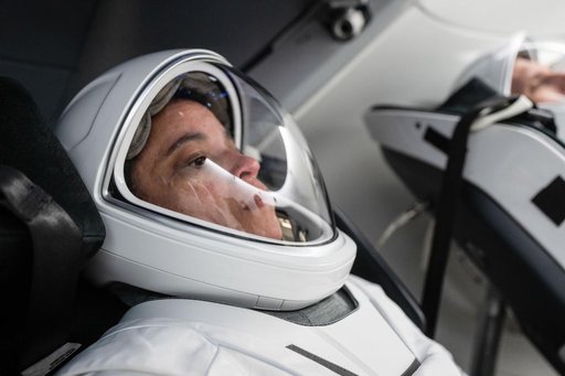 NASA astronaut Jessica Watkins is seated inside a mockup Dragon spacecraft