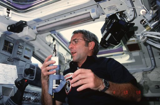 Commander Truly on aft flight deck holding communication kit assembly (ASSY)