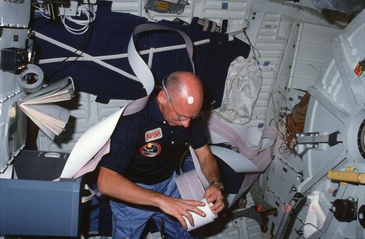 Mission Specialist (MS) Thornton rolls DSO 404 strip chart on middeck