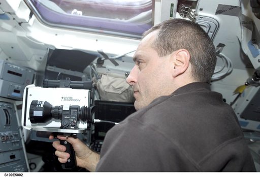 STS-109 MS Linnehan with laser range finder on aft flight deck