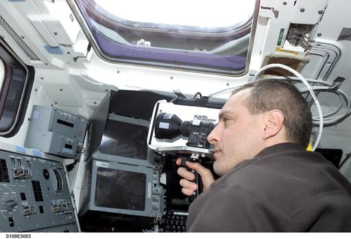 STS-109 MS Linnehan with laser range finder on aft flight deck