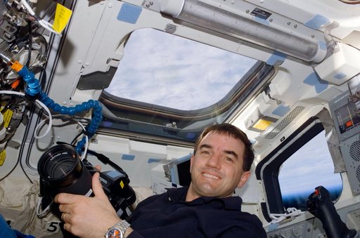 MS Walheim poses with a Hasselblad camera on the flight deck of Atlantis during STS-110