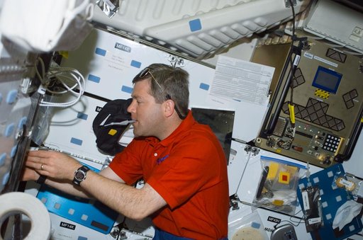 Pilot Frick gets a drink at the galley on the middeck of Atlantis during STS-110