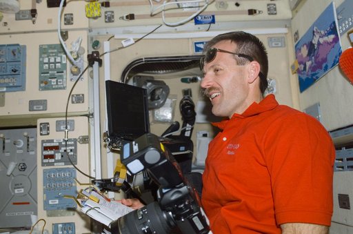 Smith with a notebook and camera in Zvezda during STS-110's visit to the ISS