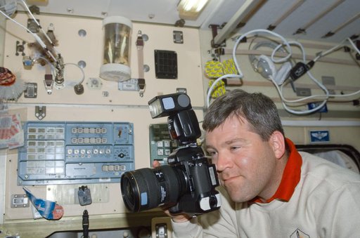 Frick uses a 35mm camera in Zvezda during STS-110's visit to the ISS