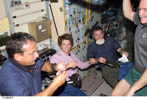 STS-114 and Expedition 11 crew share meal in Zvezda Service module