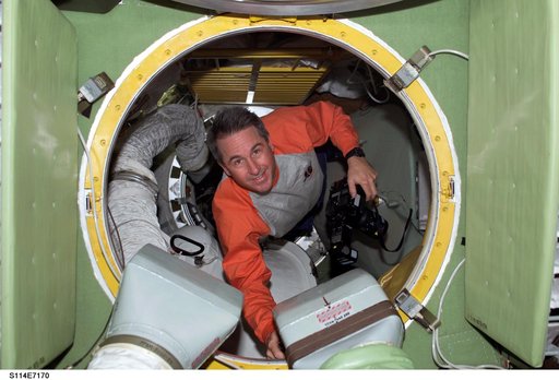 Robinson with camera in hatch leading to FGB