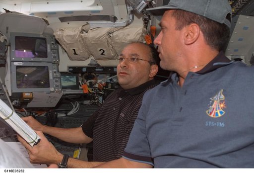 STS-116 crewmembers Polansky and Oefelin looks over crew procedures in FD on Space Shuttle Discovery