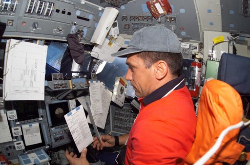 STS-116 Pilot Oefelein looks at crew procedures on Space Shuttle Discovery