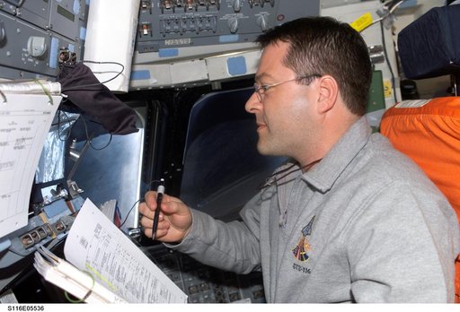 STS-116 MS Patrick looks at crew procedures in the aft FD on Space Shuttle Discovery