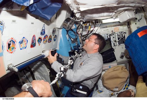 STS-116 MS Patrick looks at STS-116 Patch in the Airlock