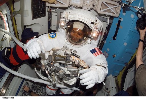 STS-116 MS Curbeam removes his EMU in the A/L on the ISS