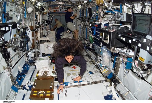 STS-116 and Expedition 14 crewmembers working in the U.S. Laboratory during Joint Operations