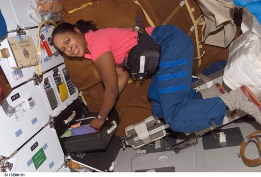 STS-116 MS Higginbotham retrieves items from a drawer in the MDDK on Space Shuttle Discovery