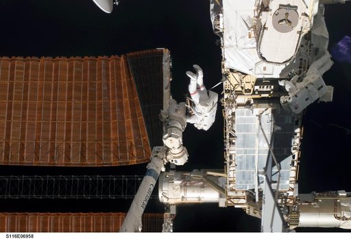 STS-116 MS Curbeam and Fuglesang work with port OVHD SAW on the P6 Truss during EVA-4
