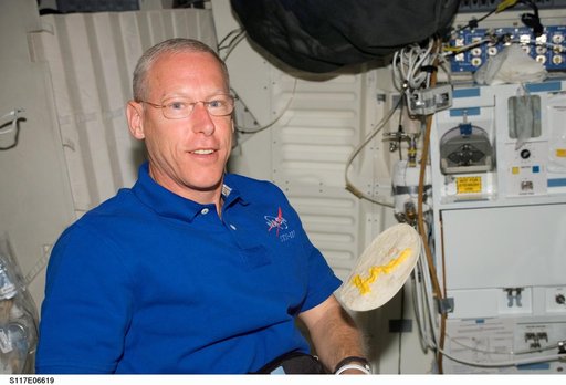 Forrester poses with floating torilla in the MDDK on STS-117 Space Shuttle Atlantis