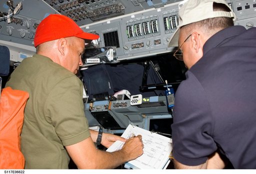 Sturckow and Archambault look over checklists on the FD of STS-117 Space Shuttle Atlantis