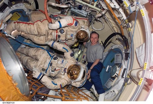 Kotov poses with Russian Orlan Spacesuits in the Pirs DC1 during Joint Operations