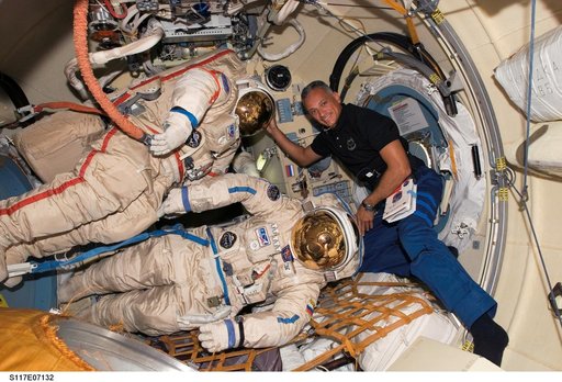 Olivas poses with Russian Orlan Spacesuits in the Pirs DC1 during Joint Operations