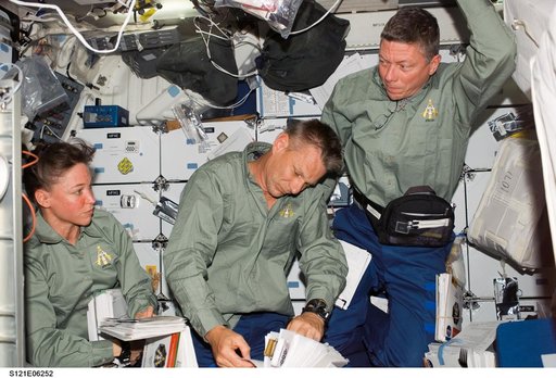 Nowak, Sellers and Fossum look over Crew Notebooks during STS-121 / Expedition 13 joint operations
