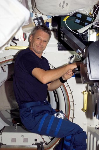 Seller types at a computer during post sleep activities on STS-121 / Expedition 13 joint operations