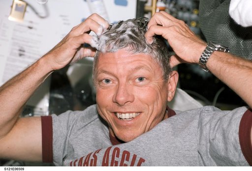 Fossum washes his hair during STS-121 / Expedition 13 joint operations