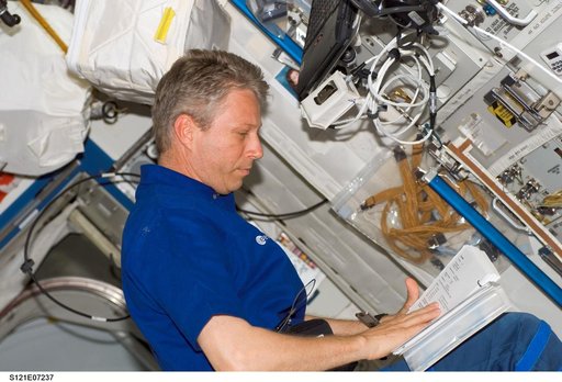 Reiter reads procedures while working in the U.S. Lab during STS-121 / Expedition 13 joint operations