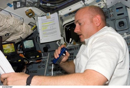 Kelly talks on a mic as he provides support from the AFD during EVA3 on STS-121 / Expedition 13 joint operations