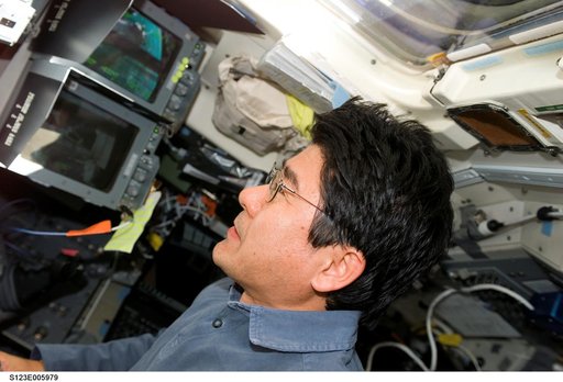 Doi watches monitor during first EVA, Joint Operations