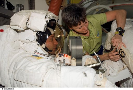 Whitson assisting Linnehan with his EMU in the A/L during Joint Operations