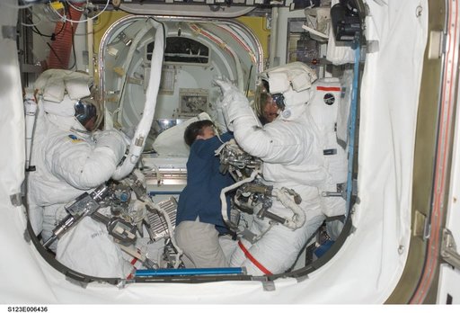 Whitson assists Foreman and Linnehan with their EMUs in the A/L during Joint Operations