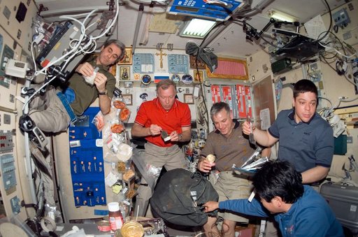 STS-123 and Expedition 16 crewmembers eating in the SM during Joint Operations