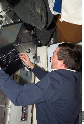 STS-123 crewmember uses laptop computer in the FWD MDDK during Joint Operations