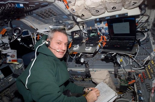 Linnehan looks over crew procedures in the aft FD during Joint Operations