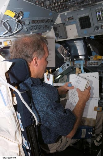 Gorie looks over checklist in the FD during STS-123