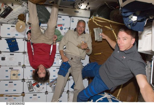 Crew Members enjoy a meal on the Shuttle Atlantis Middeck