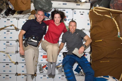 Crew Members pose for a photo on the Shuttle Atlantis Middeck