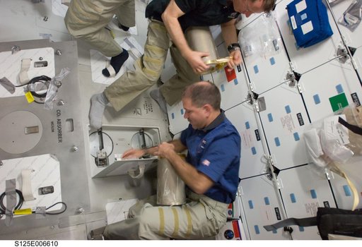 STS-125 Crew Members replace LiOH Cannisters on the Shuttle Atlantis Middeck