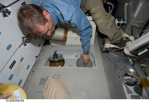 STS-125 Pilot Johnson replaces LiOH Cannisters on the Shuttle Atlantis Middeck