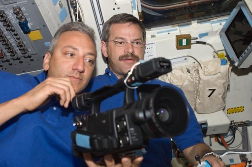 View of STS-125 Crew Members working with a Video Camera