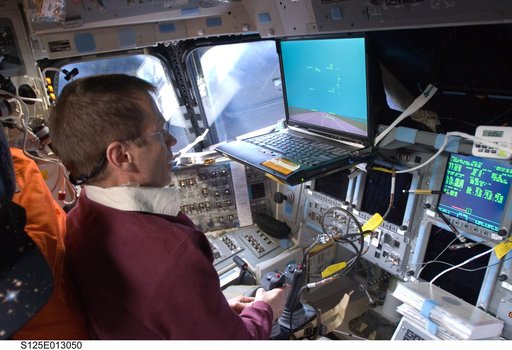 View of STS-125 Crew Members working on the Flight Deck