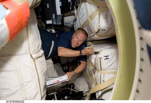 Kopra looking at crew procedures on the Space Shuttle Endeavour during the STS-127 Mission