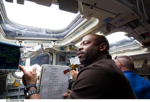 STS-129 Crew Members unberth the OBSS