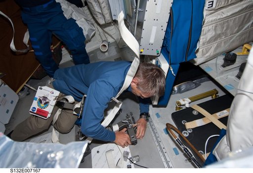 Sellers works at the CO2 Absorber Panel Door in the MDDK during STS-132