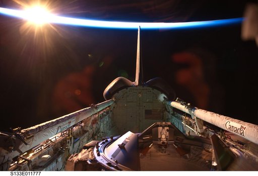 Orbital sunrise over Discovery payload bay