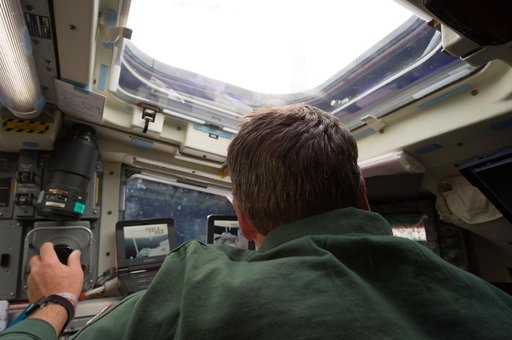 View of STS-134 MS Vittori working on the Flight Deck