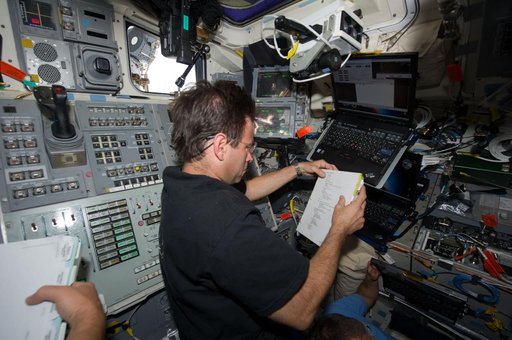 STS-134 MS Chamitoff reads a Procedures Checklist