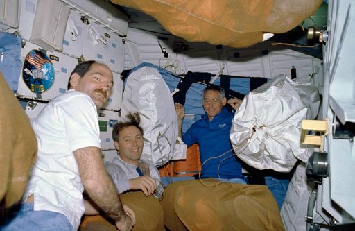 STS-27 crewmembers surrounded by net stowage bags on middeck
