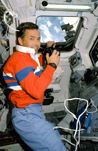 STS-30 Pilot Grabe uses 35mm camera on aft flight deck