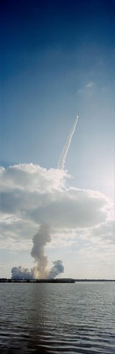 STS-31 Discovery, OV-103, rockets through low-lying clouds after KSC liftoff